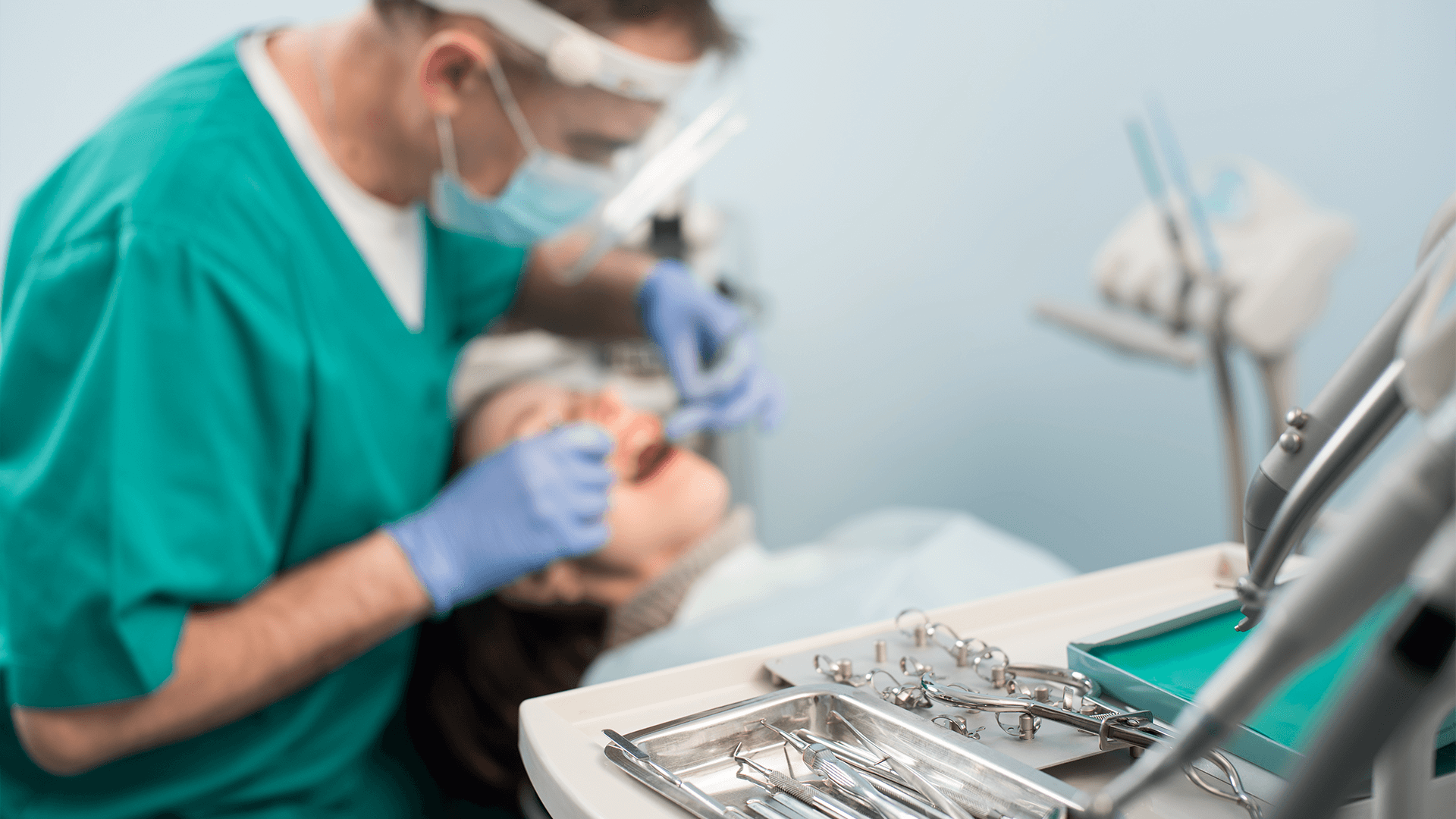 Dental tools are shown and in the background a dentist checking a client.
