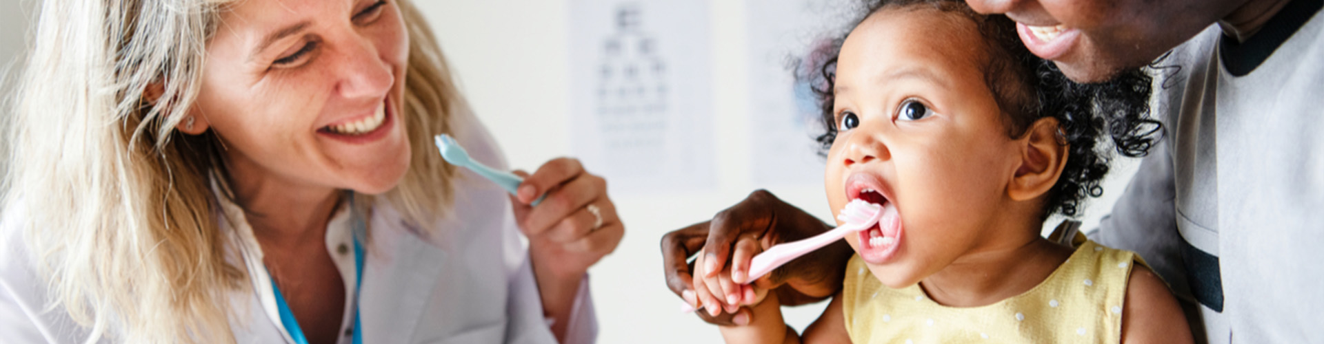 Dentist watching child brush her teeth.