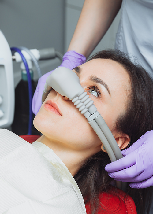 A woman at the dentist with a mask getting sedation.