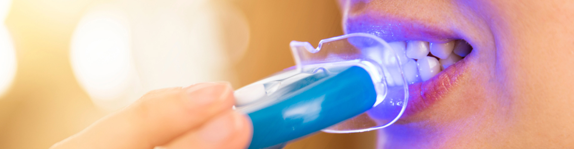 person having LED teeth whitening.