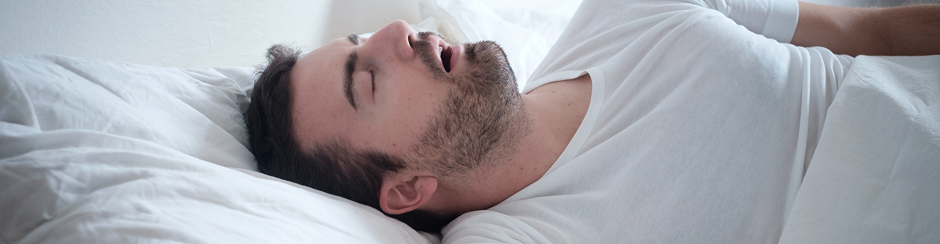 man laying on his back asleep with his mouth open.