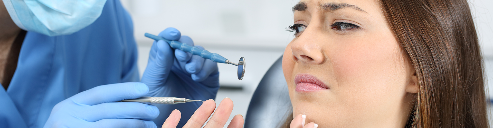 woman pushing awat dental tools in dentist's hands.