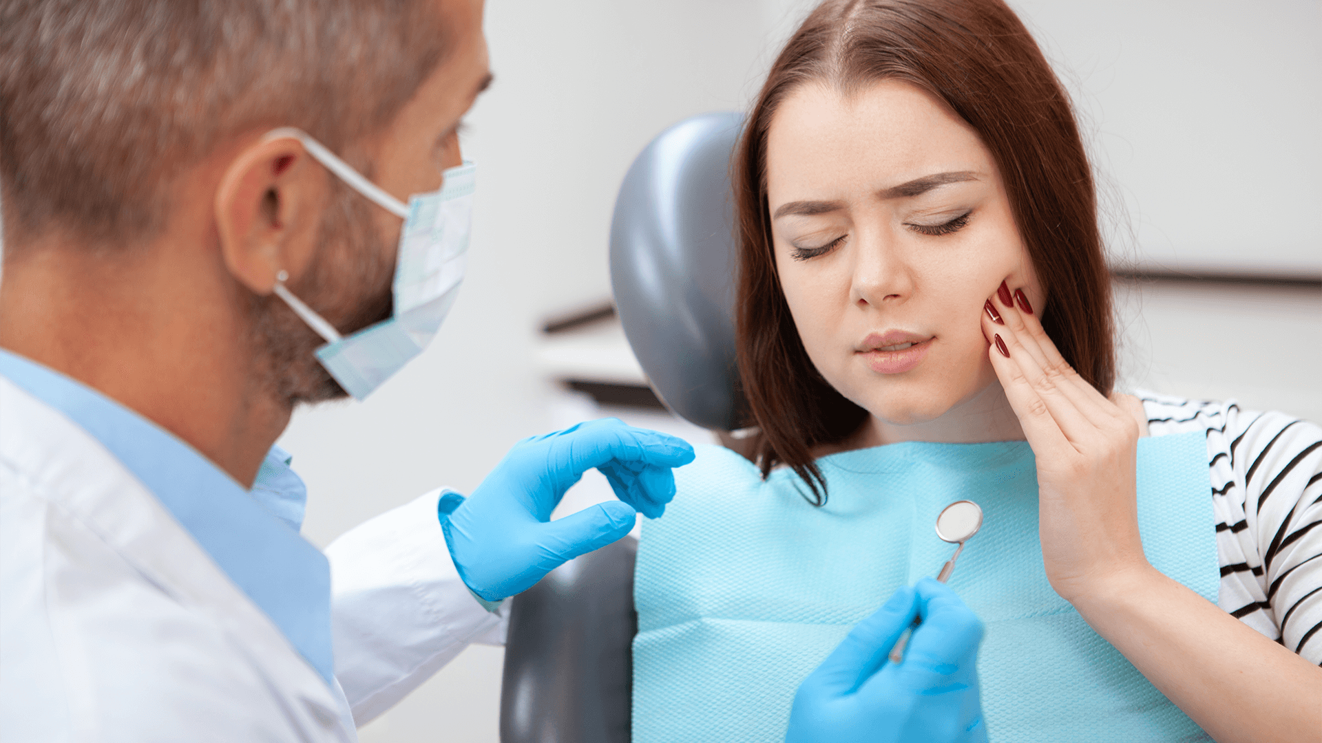 Young woman with toothache at the dentist.