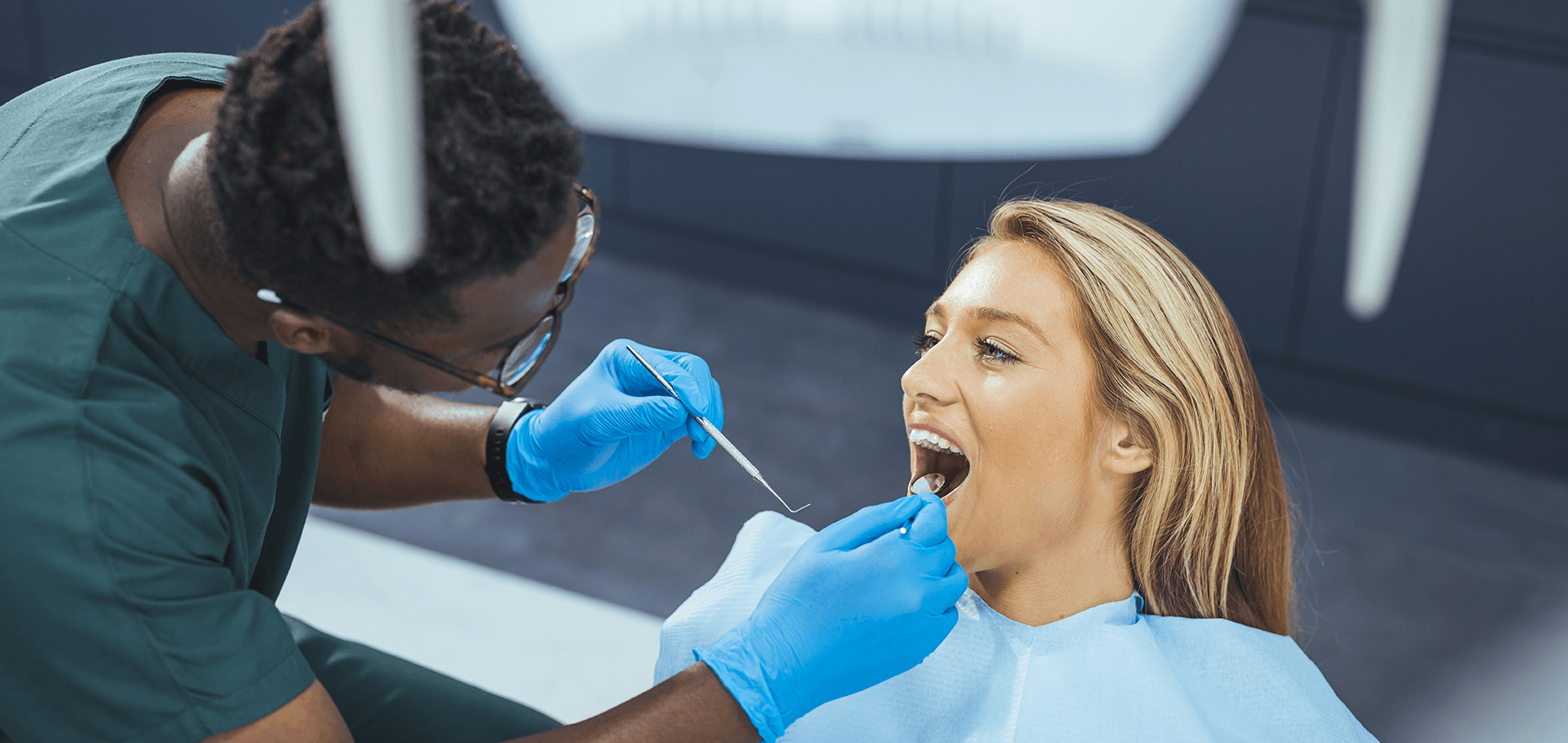 Dentist looking at tooth color in woman's smile.