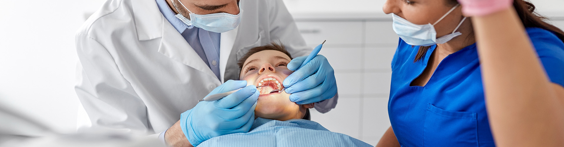 dental staff working in patient's mouth.