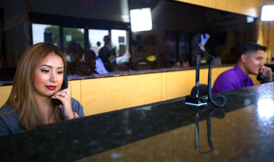 Two front desk staff talking on the phone at a dental office.
