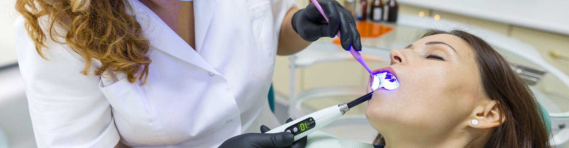 dental professional performing treatment on a sleeping female patient.